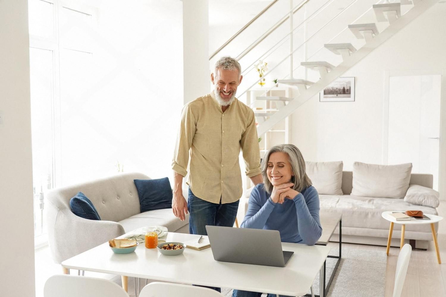 Older couple comparing apartment insurance policies at their dining table in Dubai